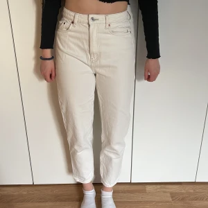 Vita jenas  - Vita jeans i ankelhöjd. Momjeans. Modellen bär vanligtvis storlek 36 och är 168cm lång