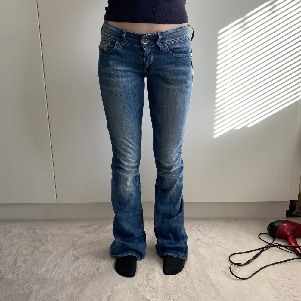 Lågmidjade jeans. Utsydda nedtill. Hon på bilden är 166 och midjemåttet på henne är 80cm och innerbenslängden på henne är ca 80cm (kanskd lite mindre). Hör av dig vid mer frågor💞. Jeans & Byxor.