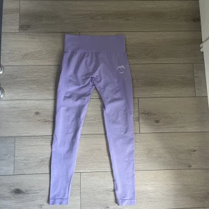 Träningstights  - Säljer dessa tights från peachtights i pastelllila då dom är lite stora. Använda en gång. Nypris 549kr