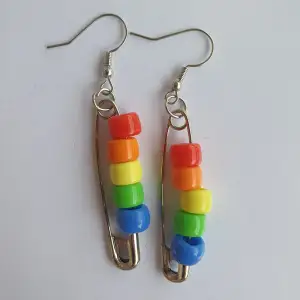 Regnbåge-, bisexuell-, trans-flaggor örhängen gjorda av säkerhetsnålar och pärlor
