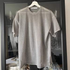 Glittrig T-shirt från Zara, genomskinlig. Storlek S