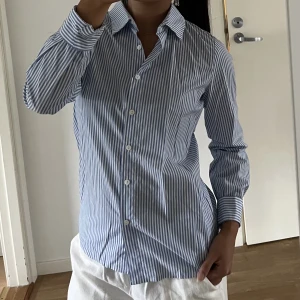 Blåvit randig skjorta - Blåvit randig skjorta från Grunt. Använd endast ett fåtal gånger, i mycket fint skick! 🩵🤍