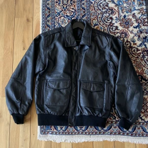 Läderjacka - Snygg svart läderjacka i äkta läder, innerfodret är bomull och polyester. Storlek M, står märket ”Harvey” på insidan. 