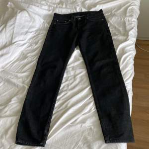 Tjo tjo, säljer mina svartgråa arket jeans som inte används på ett tag. Jeansen har en slimmad passform runt låren och en lite mer relaxed runt vaderna. Det står 29 i midjan på jeansen men de sitter mera som en 30