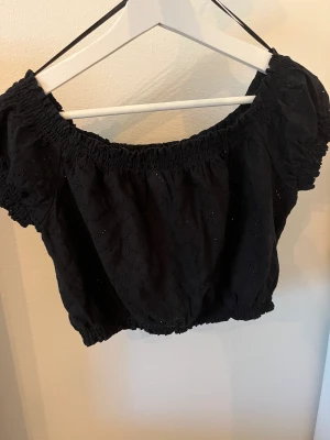 Svart cropped topp - Fin svart topp med små håll som gör den skön för sommaren. Endast använt 2 gånger 