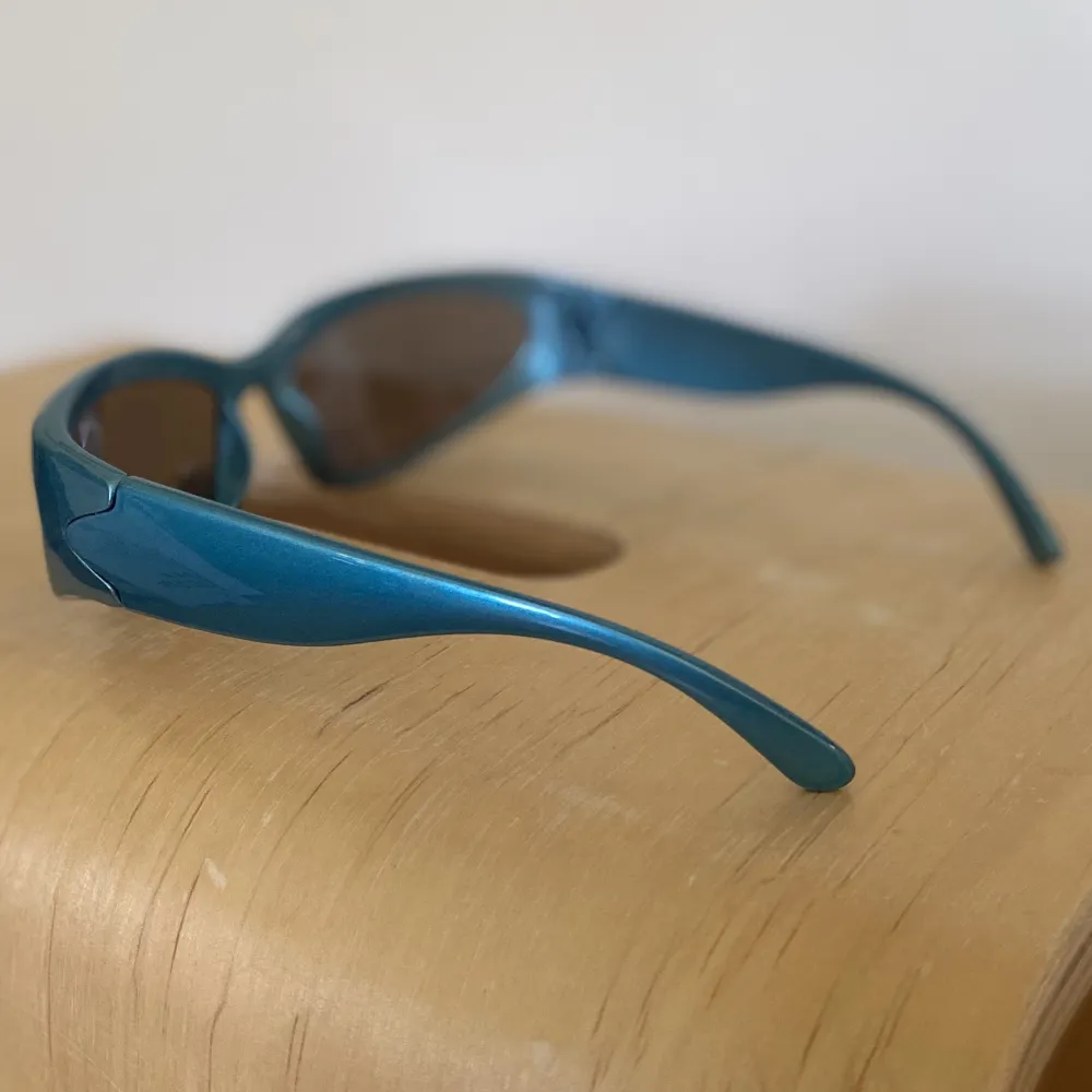 Snygga metallicblå solglasögon med brungråtonat glas. Tror tyvärr ej de har något UV skydd då de är köpta på Shein. Använda 2 gånger och i gott skick.. Accessoarer.