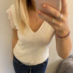 T-shirt/blus - Fin vit t-shirt med fint mönster. Är osäker på märket men kan skicka bild på lappen!