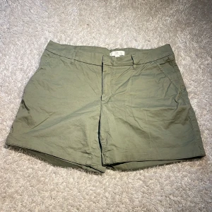 Olivgröna shorts - Korta olivgröna shorts från HM i storlek 42, bakfickorna är fake, knappt använda