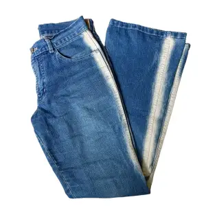 Utsvängda jeans med blekta detaljer längst benen!