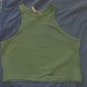 Grön Topp - En grön topp i storlek L - från H&M! Tyckte om den i omklädningsrummet men upptäckte senare att färgen inte var min favorit… så låter någon annan färgglad människa njuta av denna!🌈