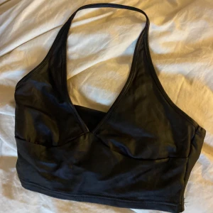 Halterneck i skinn - Svart halterneck i skinnmaterial. Verkligen supersnygg på!