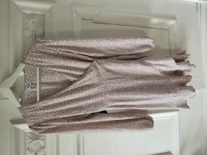 Omlottklänning strlk 36 - Superfin knappt använd blommig peige omlottklänning från bubbelroom i strlk 36.