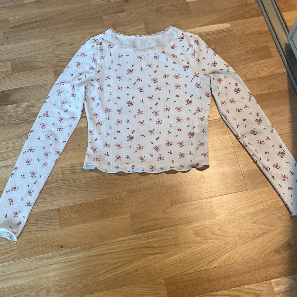 Vit långärmad med röda blommor på