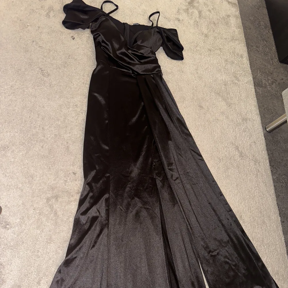 Svart maxi klänning, perfekt längd om du är 165 cm. Omlott upptill, split och sidomantel nedtill. Endast andvänt en gång. Köpt för 2500kr säljs nu för 1200kr. Klänningar.