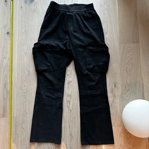 Flared Cargo Byxor - Flared Cargo Byxor. Svarta. Elastisk midja men sitter som storlek. W30-32 L30. Liten flaw hål i ena fickan
