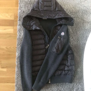 Moncler cardigan - Säljer denna gråa moncler cardigan för att den är för liten för mig. Skick 9/10, använd men i bra skick. Tveka inte på att höra av dig!