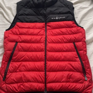 Sail racing väst - Röd svart sail racing väst i storlek M som är använd ett fåtal gånger. Skicket är 9/10 och nypris är ca 2000kr. Mitt pris 800kr vid snabb affär 700kr