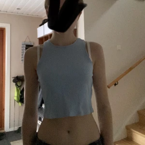 Blå tank topp - En ljusblå ribbad tank topp från 🤷‍♀️ Använd ca 3 gånger och är felfri. Strl. M men kan passa till mindre men blir då lite stor vid midjan.🙌🏼