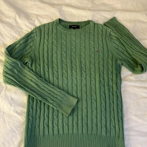 Gant kabelstickad tröja S  - Säljer en kabelstickad tröja från Gant i storlek S. Den har gått upp lite i sömnen på främre sidan av kragen, se bild, annars i fint skick.