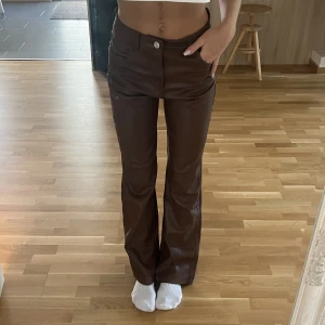 Skinnbyxor Bershka - Bruna fake skinnbyxor från Bershka. Inget att anmärka på. High waist men enkla att sy om till lägre om man är ambitiös. Bekväm mjuk insida. Bootcut. Storlek S, midja rakt över 35cm, innerben 81 cm. Stretchiga. 
