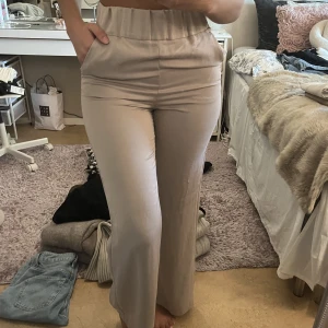 Högmidjade beiga byxor - Ett par högmidjande byxor köpt från hm. Jätte skönt material som är av lyocell och polyester. Aldrig använda. Är väldigt små på mig därför används dom inte. Storlek XS. 