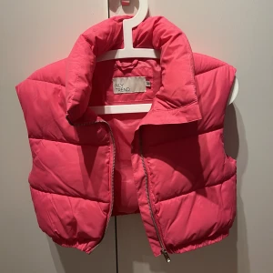 Cropped puffer vest - Vadderad väst från Nelly i storlek 34. Använd 1 gång sen dess har den bara hängt. Som ny🩷
