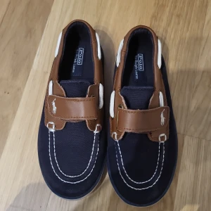 Polo ralph lauren barnsko  - Fina barnskor ifrån märket Polo by Ralph Lauren. Skorna är sparsamt använda en säsong. Storlek 26,5 (15 cm) 