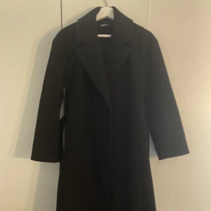 Kappa - Lång svart kappa i tight modell. Köpt förra hösten för 799kr.