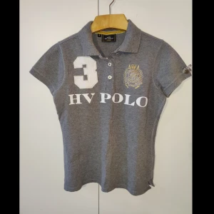 HV Polo Piké - Grå HV Polo Piké t-shirt. Helt ny endast testad. Snygg, skön och perfekt för en dag i stallet 🐴  Pris går absolut att diskutera om vi möts upp🌸  Nypris: 845kr
