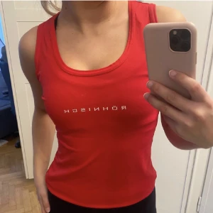 Röhnish träningslinne - Rött träningslinne från Röhnisch strl 34-36/S. Fint skick o så skönt material att träna i, texten på bröstet har lite sprickor men det är inget som syns om man inte tittar noga. 🥰