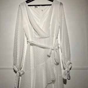 Klänning  - Vit omlottklänning från dennismaglic. Super fin och man kan knyta den på fler tänkbara sätt.  Använd en gång. Nypris 900. Säljer för 750, kan även gå ner i pris vid snabb affär. 