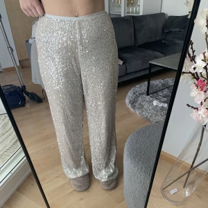 Silvriga glitterbyxor  - Silvriga paljettbyxor från River Island. De är i storlek 12, vet inte helt vad det motsvarar men jag brukar ha 40 i byxor.💞🌟 De är endast använda en gång, de finns lite småtrådar som dragits upp pga paljetterna men dessa borde kunna gå att klippa av!💞 