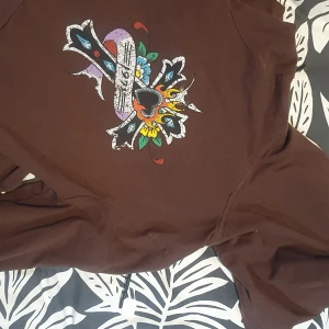 Ed hardy cropped hoodie  - Köpte den i Stockholm, Urban outfiters, Maj 2022 men använt kanske 3 gånger- nyskick. Säljer pga inte min stil längre. Köpt för 800, säljer för 650+frakt . (Den är cropped, men täcker naveln på mig) ❤️
