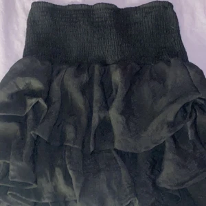 Svart volang kjol - Svart volang kjol, lite liten i storleken. Aldrig använd 