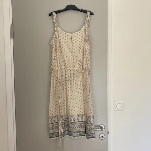 Kort sommarklänning - Kort mönstrad klänning från ESPRIT med ett gulligt band som knytes runt midjan. (Går att ta av helt) Luftigt material men inte genomskinlig Perfekt till både vardags och finare tillfällen.  Passar både M, S och XS