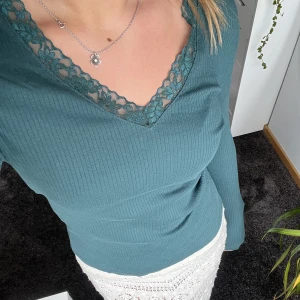 Grön tröja  - Super fin grön långärmad v ringad tröja från Vera Moda🤩. Med spetsdetaljer runt v ringningen. Använt fåtal gånger. Köparen står för frakten💕💕