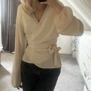 begie blus - jätte söt begie tröja från gina tricot, man nyter omlott över & knyter med en rosett. lite genomskinlig men funkar enkelt att ha ett linne under🥰