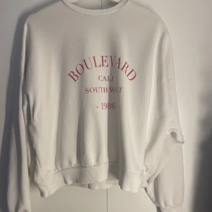 Sweatshirt - Vit sweatshirt med röd text, storlek S. Tröjan är lite oversize och är från Nelly. 60 kr + frakt🫶🏼