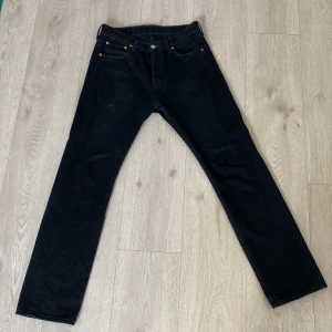Svarta Levi’s jeans  - Svarta 501 levi’s jeans. W30 L32. Har använt dem ett fåtal gånger. Men insett att dom är lite små. De är helt hål fria, men är däremot lite lite utsliten runt höger fickan. 