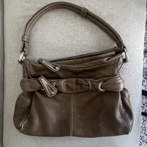 vintage brun handväska  - Vintage axelväska köpt seconhand, märke toscani. höjd 23cm, bredd 32cm 