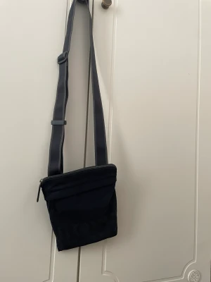 Hugo boss axelväska - Riktigt snygg axelväska av Hugo boss pixelverision och den är svår att få tag i, den är ganska använd men den är i bra skick.