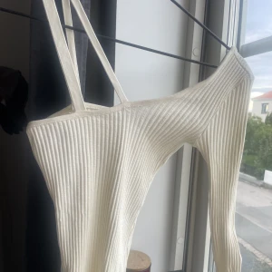 One shoulder topp ZARA - Vit One shoulder topp från ZARA, (framkommer inte riktigt på bilden) band på andra sidan sitter på motsvarande axel! Använd max 2 gånger så i bra skick! Skriv för frågor 🌟