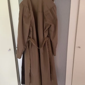 Otroligt fin trenchcoat med päls - Säljer nu denna fantastiska vintage kappa i otroligt gott skick. Den har inga lappar i sig som anger storlek eller märke, men skulle uppskatta att den är ungefär en 38:a. Pälsfodringen är avtagbar med knappar i nacken. Jättefina detaljer