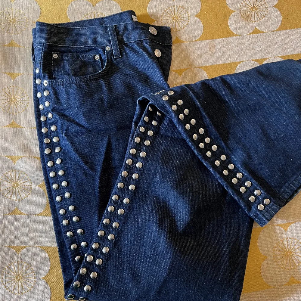 Vida extra långa jeans med nitar längs hela sidorna. Marinblå med en svag metallisk känsla. Höga i midjan och ett skönt material. Inga skador.. Jeans & Byxor.