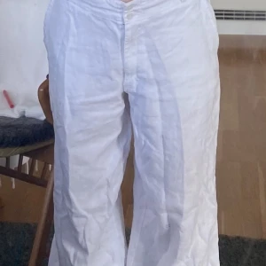 Vita linnebyxor  - Supersköna linnebyxor. De är långa och vida i benen. Med fina knappar. Längst ner på byxbenet finns det gråsmuts men det borde gå att få bort med fläckborttagningsmedel 