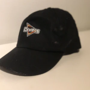 Doritos keps - En cool doritos keps. Den är svart och har deras logga på. Kom med pris förslag😉💕
