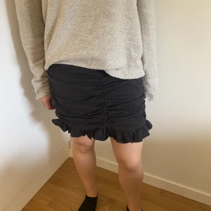 Svart kjol  - En väldigt fin ganska kort svart kjol med snygga detaljer. Väldigt fint skick endast använd få gånger.