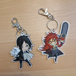 Black Butler nyckelringar - Nyckelringar med Sebastian och Grell från Black Butler. 30 kr styck eller 40 för båda.  Kan skickas som brev, då blir frakten 15 kr, skriv så fixar vi det! 🥰