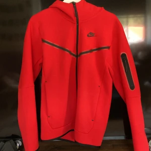 Röd Nike tech fleece  - Säljer en röd Nike tech fleece på grund av att den är för stor har aldrig använt den eller knappt rört den. Nypris 1350 