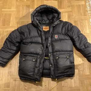 Fjällräven expedition down jacket - Jag säljer min fina fjällräven expedition down jacket i storlek Xs. Snygg och varm jacka som passar till det mesta! Nått år gammalt och ett litet hål vid armen och ett spänne som är sönder därför är priset lägre , men annars fint skick. 